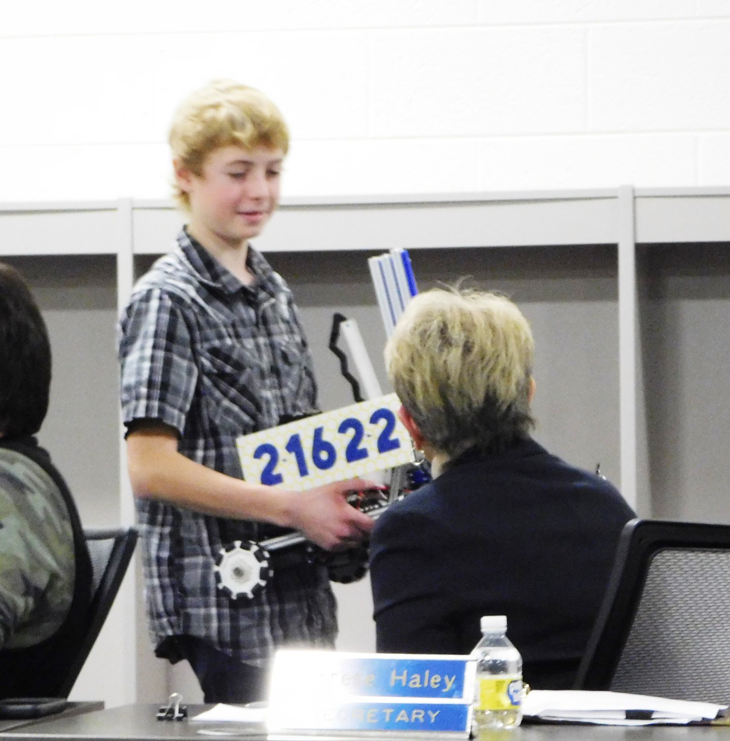 Harrison Middle School student and MS Robotics participant Eli Wing shows his group’s robot to school board member Therese Haley during the BOE’s Jan. 9 meeting.
